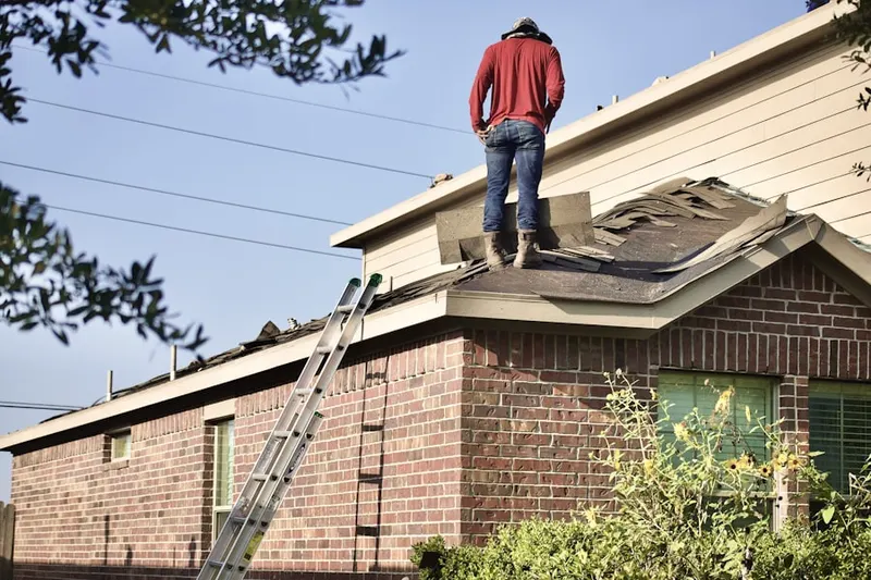 Professional roofer working on a residential roof in Merrimack